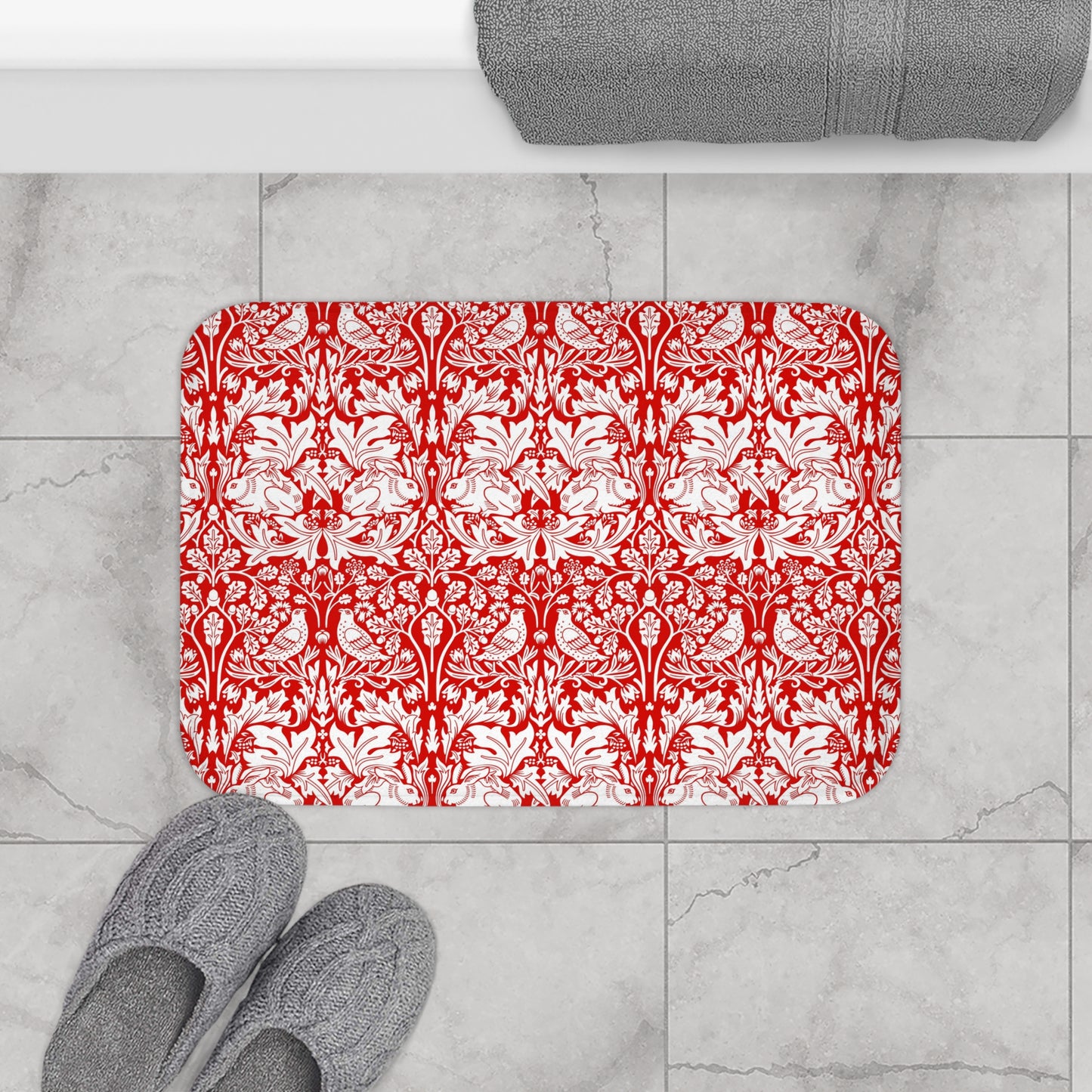 Decorative red and white patterned rug on a marble floor with gray slippers and a towel.