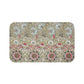 A rectangular microfibre bath mat with a floral pattern inspired by William Morris, predominantly in beige, green and pink colours.
