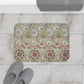 A rectangular microfibre bath mat with a floral pattern inspired by William Morris, predominantly in beige, green and pink colours.