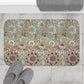 A rectangular microfibre bath mat with a floral pattern inspired by William Morris, predominantly in beige, green and pink colours.