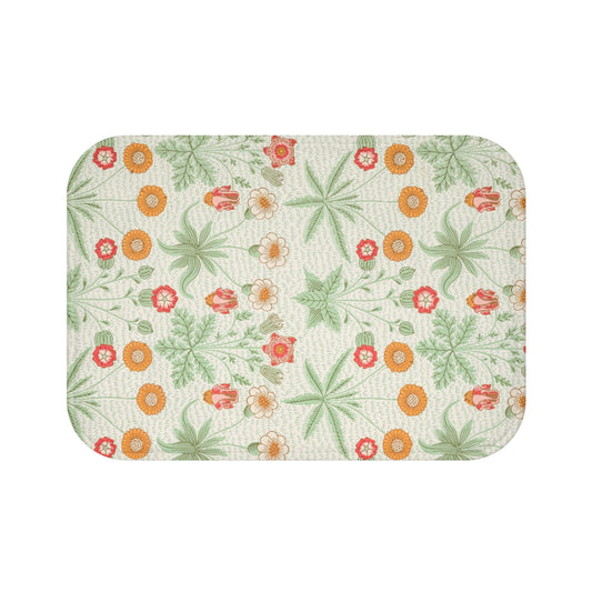 A rectangular microfibre bath mat with a floral pattern inspired by William Morris, featuring colors predominantly in green and orange.