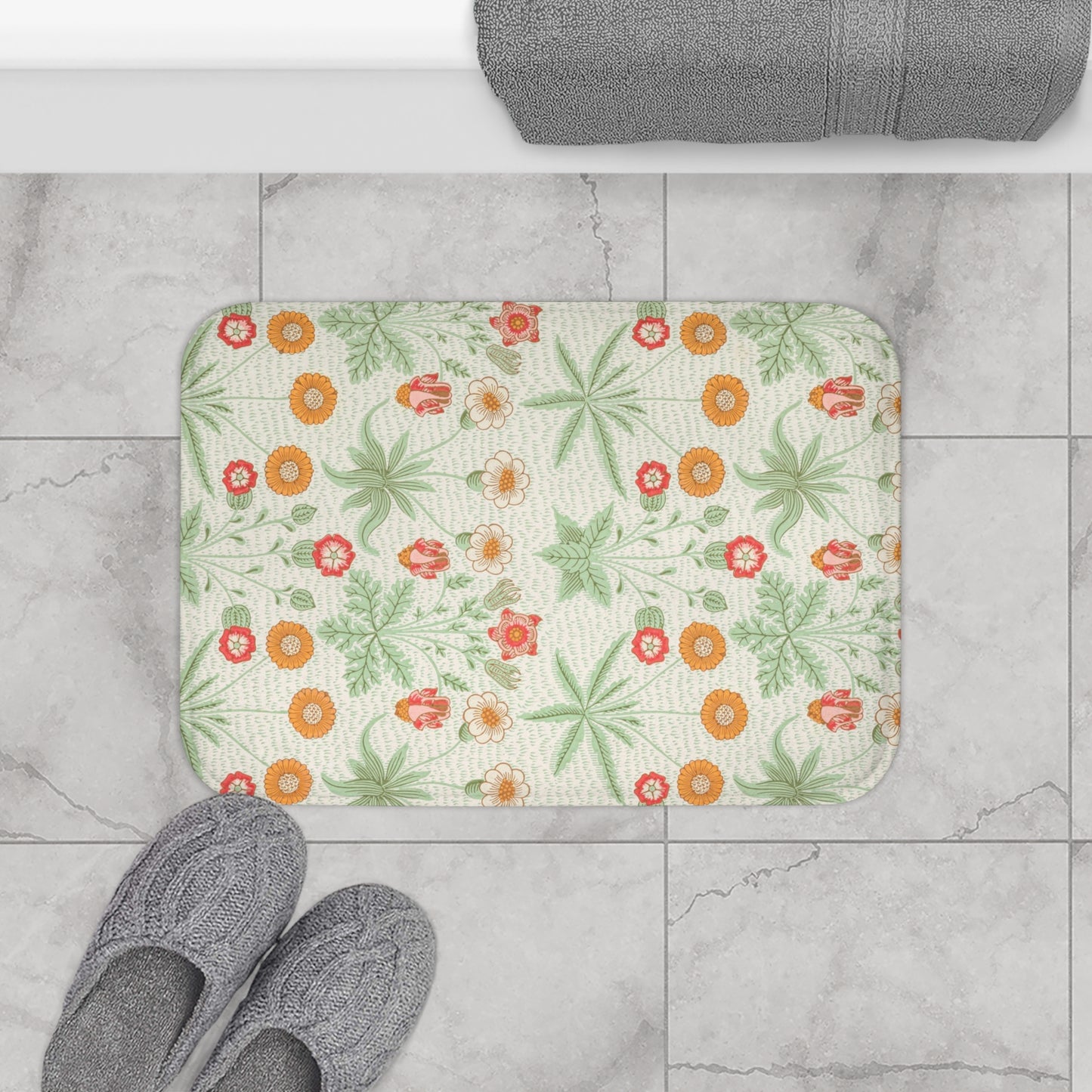 A rectangular microfibre bath mat with a floral pattern inspired by William Morris, featuring colours predominantly in green and orange.