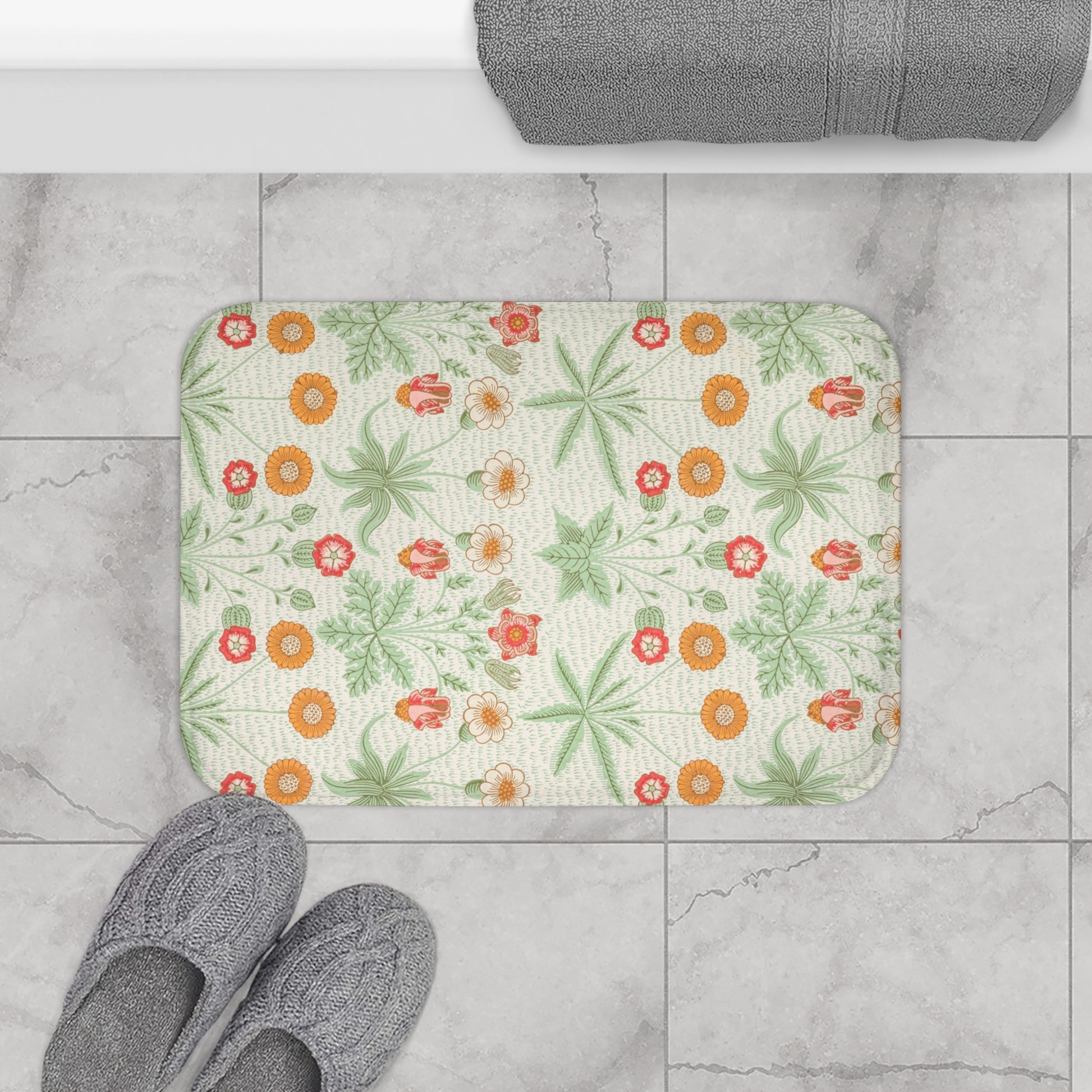 A rectangular microfibre bath mat with a floral pattern inspired by William Morris, featuring colours predominantly in green and orange.