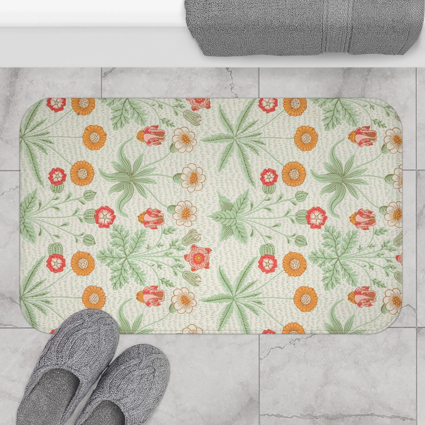 A rectangular microfibre bath mat with a floral pattern inspired by William Morris, featuring colours predominantly in green and orange.