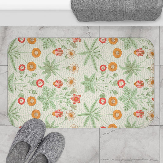 A rectangular microfibre bath mat with a floral pattern inspired by William Morris, featuring colours predominantly in green and orange.