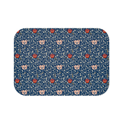 A rectangular microfibre bath mat with a floral pattern inspired by William Morris, predominantly blue with red and white accents.
