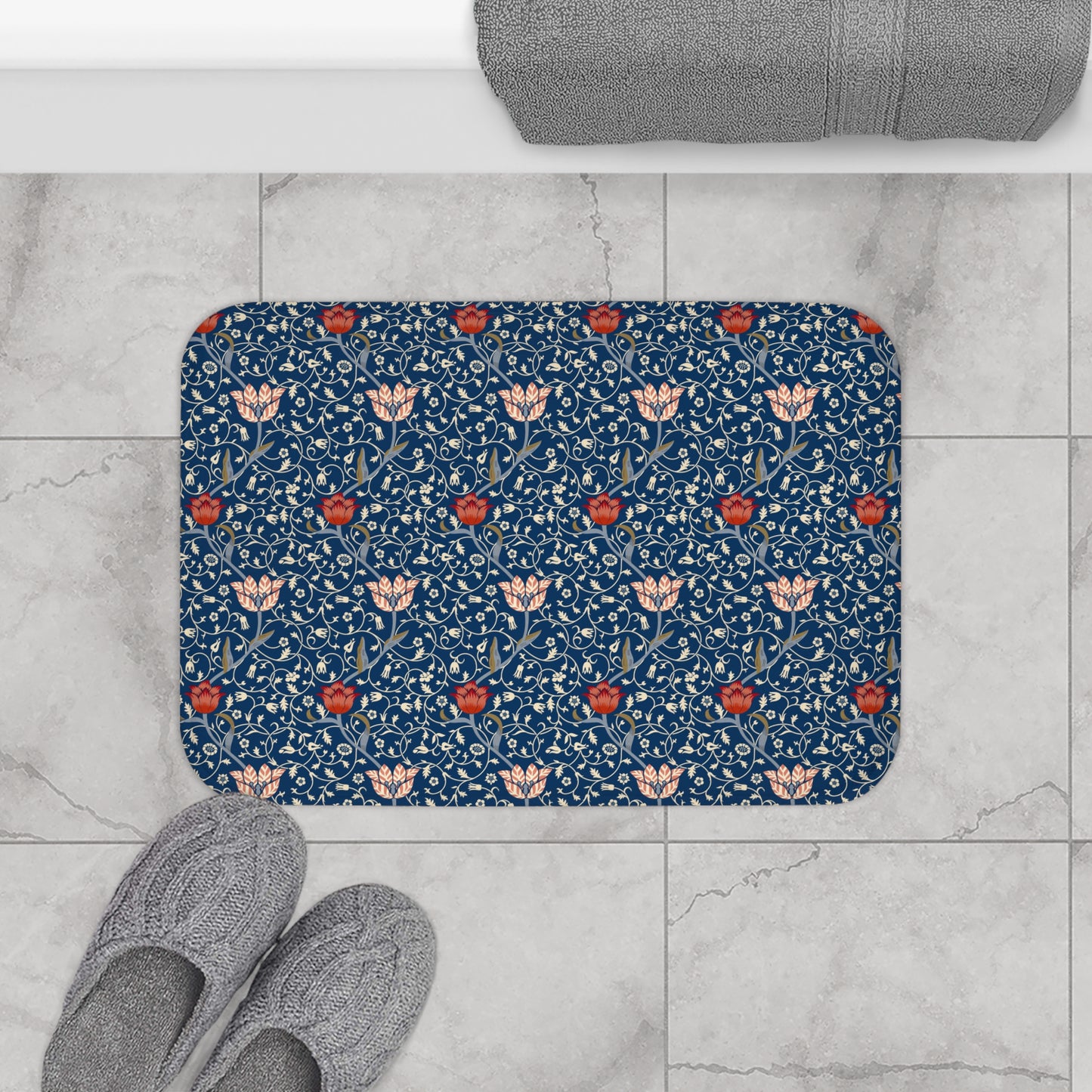 A rectangular microfibre bath mat with a floral pattern inspired by William Morris, predominantly blue with red and white accents.