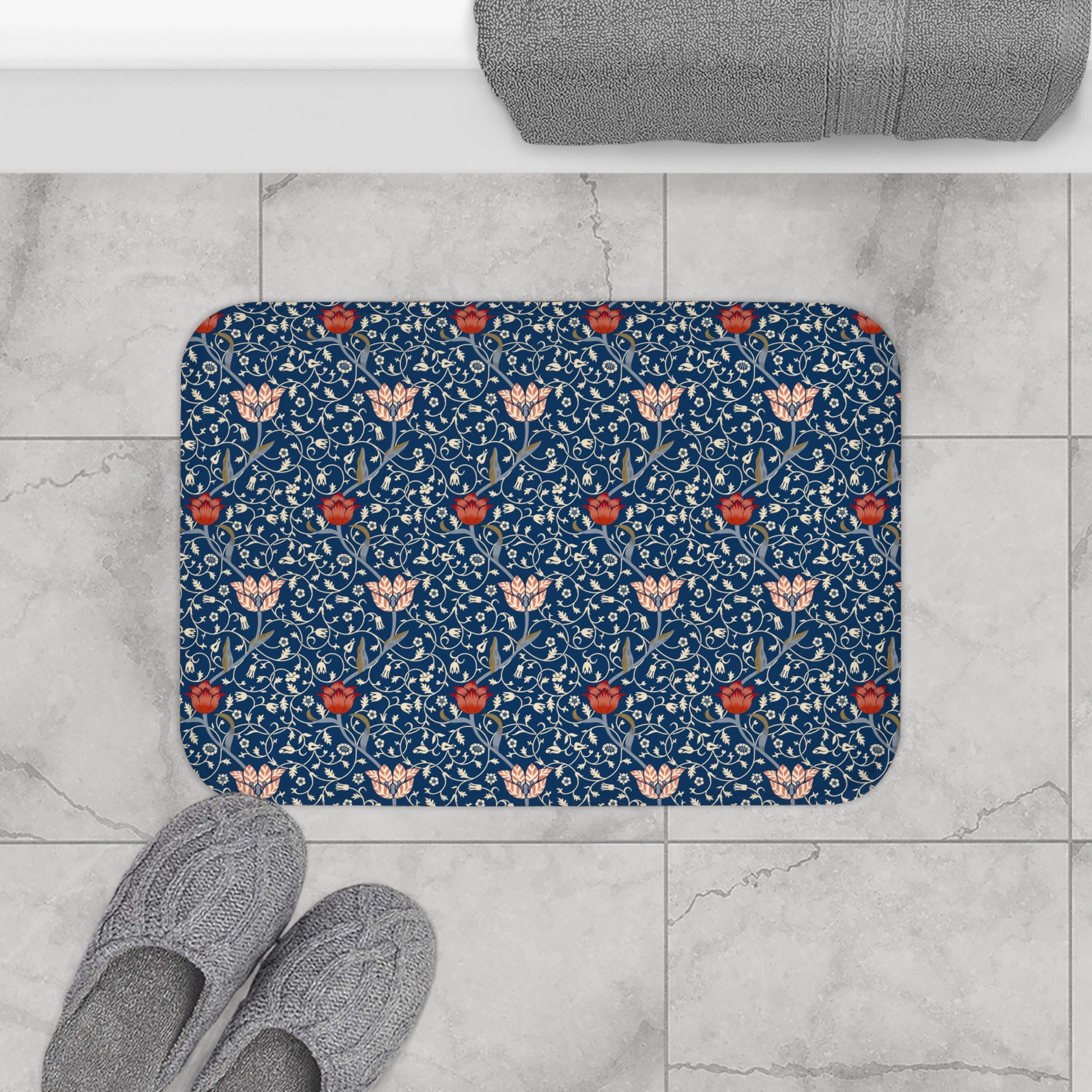 A rectangular microfibre bath mat with a floral pattern inspired by William Morris, predominantly blue with red and white accents.