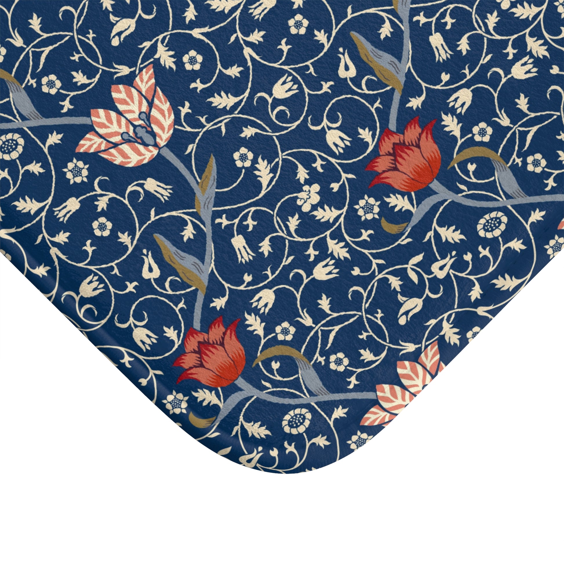 A rectangular microfibre bath mat with a floral pattern inspired by William Morris, predominantly blue with red and white accents.