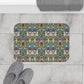 Decorative doormat with a colorful pattern on a tiled floor with slippers and a towel.