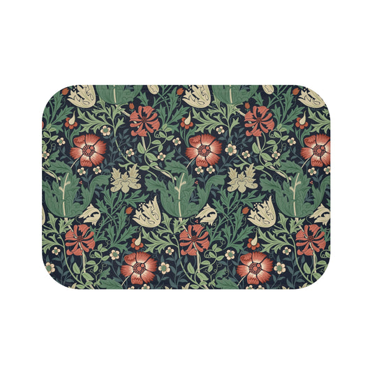 Rectangular microfibre bath mat with a floral pattern inspired by William Morris, in colours green, red, and beige.
