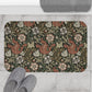 A rectangular microfibre bath mat with a floral pattern inspired by William Morris, in colours brown, beige, and green.