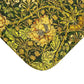 A round microfibre bath mat with a floral pattern in gold, brown, and green colours, inspired by William Morris - Honeysuckle Collection.