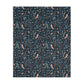 Patterned William Morris & Co blanket with birds and leaves on a dark blue background