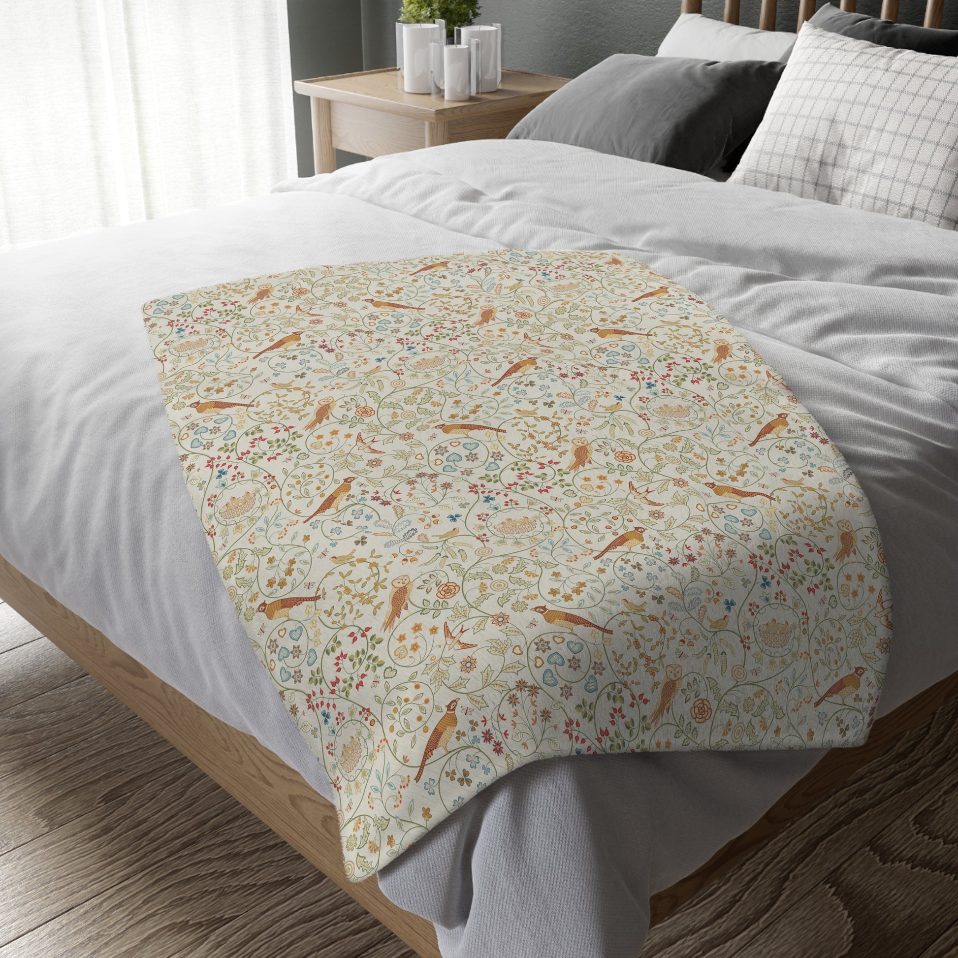 Floral patterned throw blanket on a bed with white bedding