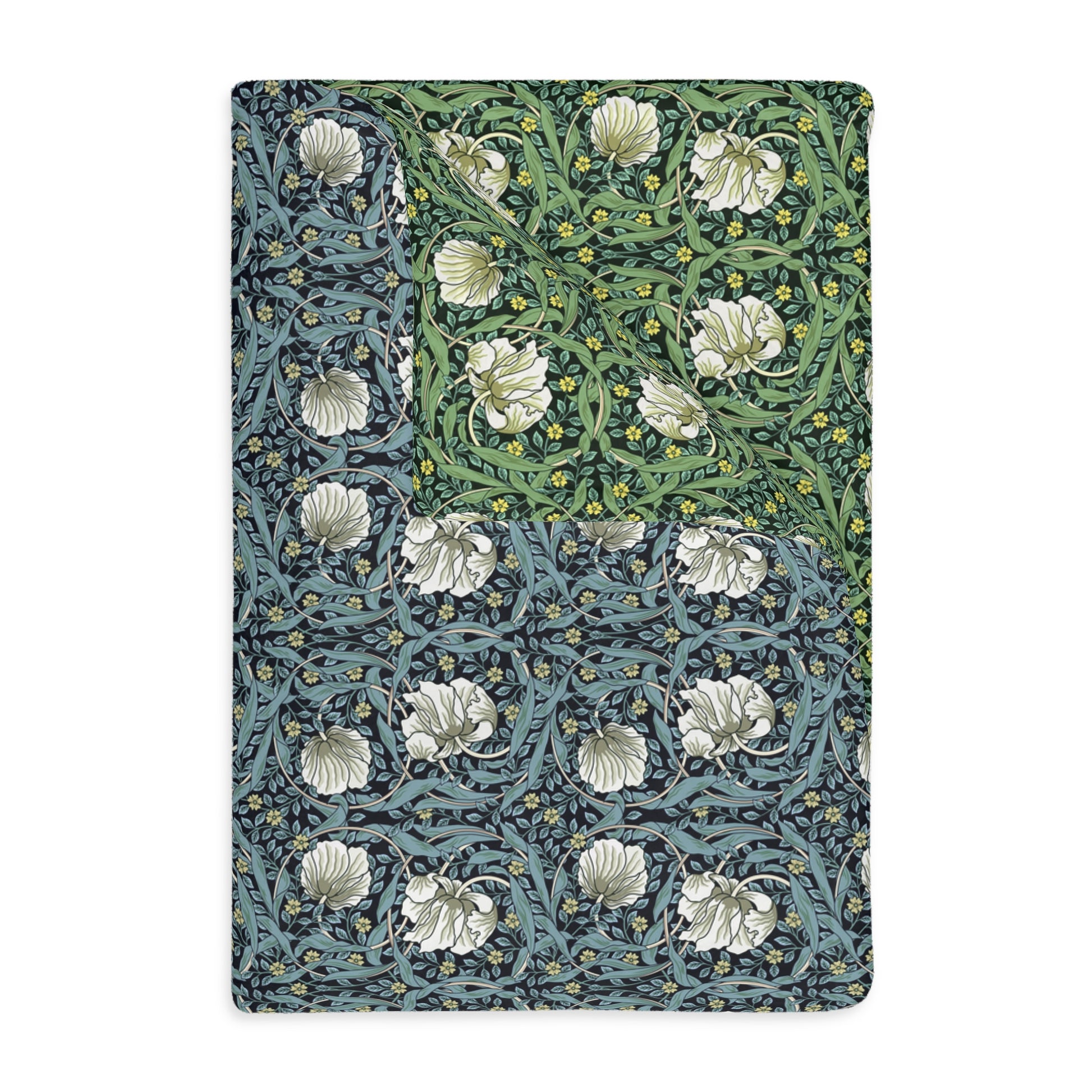 A rectangular blanket with a two-sided print featuring William Morris & Co floral patterns in shades of slate and green in a pattern called Pimpernel with a luxurious velveteen texture.