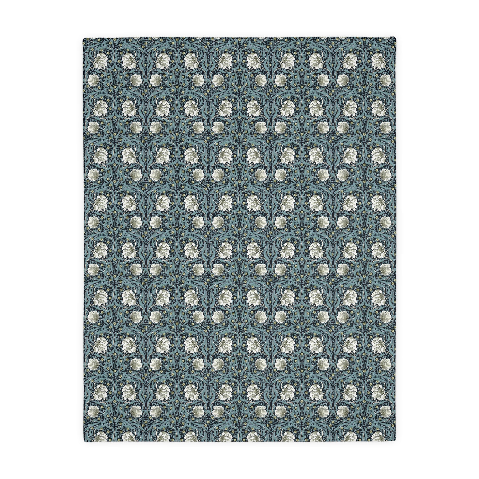A rectangular blanket with a two-sided print featuring William Morris & Co floral patterns in shades of slate and green in a pattern called Pimpernel with a luxurious velveteen texture.