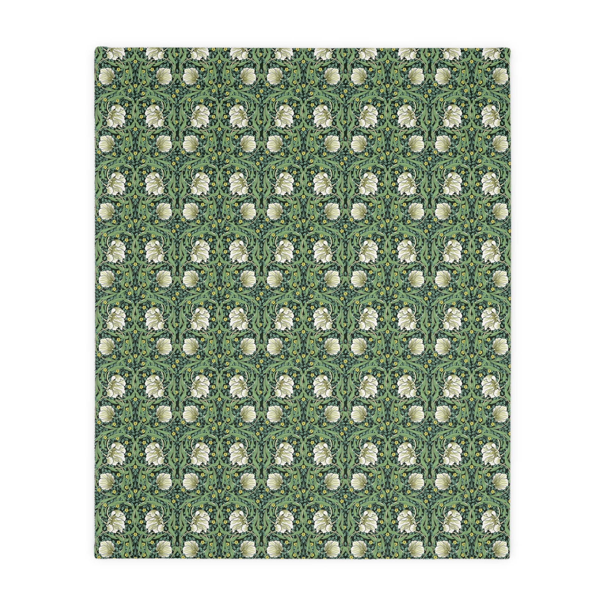 A rectangular blanket with a two-sided print featuring William Morris & Co floral patterns in shades of slate and green in a pattern called Pimpernel with a luxurious velveteen texture.