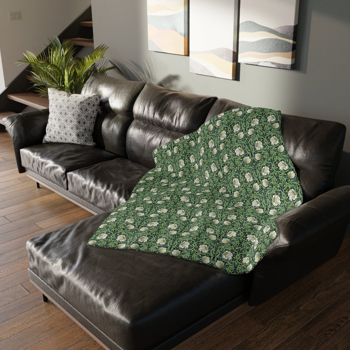 A rectangular blanket with a two-sided print featuring William Morris & Co floral patterns in shades of slate and green in a pattern called Pimpernel with a luxurious velveteen texture.