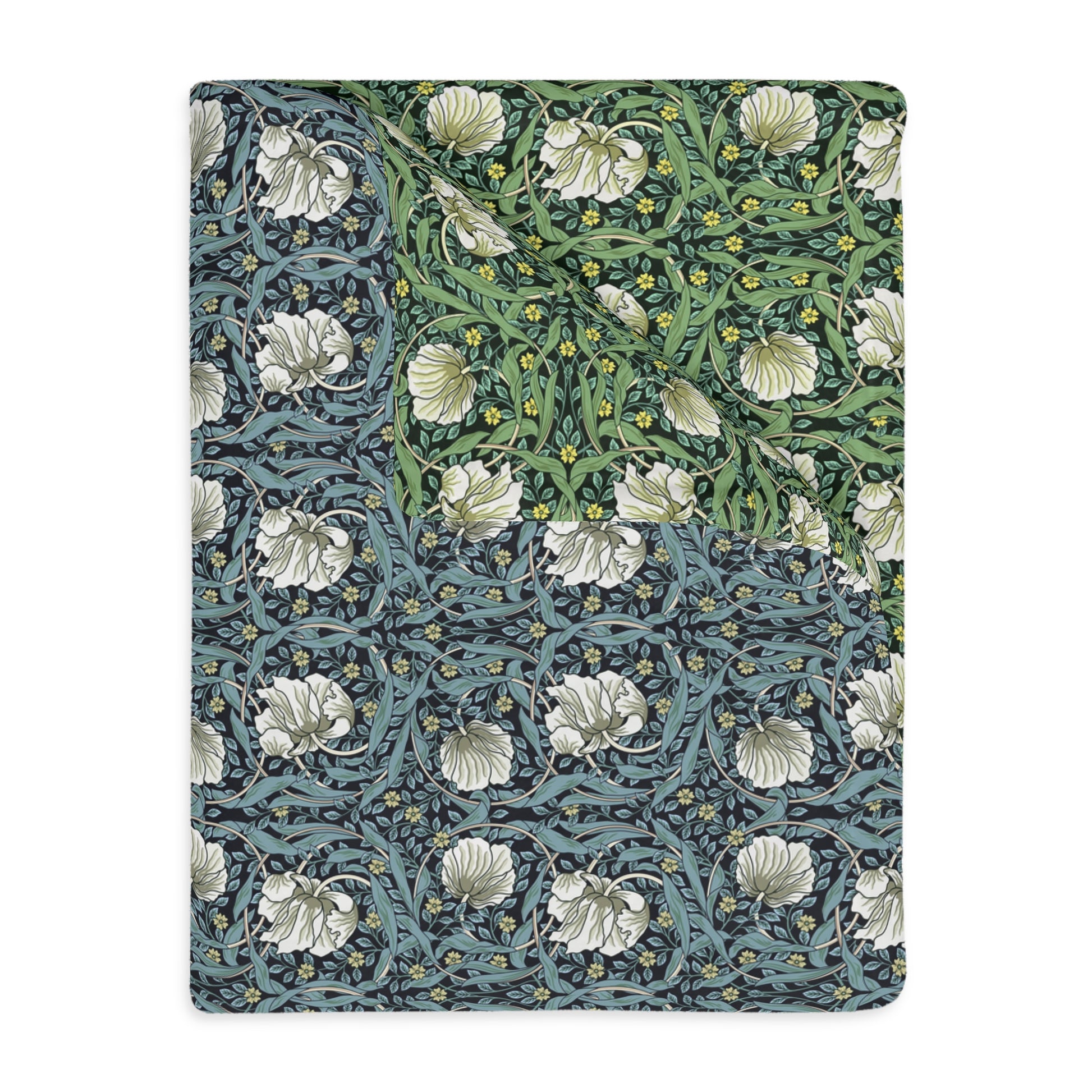 A rectangular blanket with a two-sided print featuring William Morris & Co floral patterns in shades of slate and green in a pattern called Pimpernel with a luxurious velveteen texture.