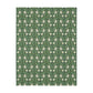 A rectangular blanket with a two-sided print featuring William Morris & Co floral patterns in shades of slate and green in a pattern called Pimpernel with a luxurious velveteen texture.