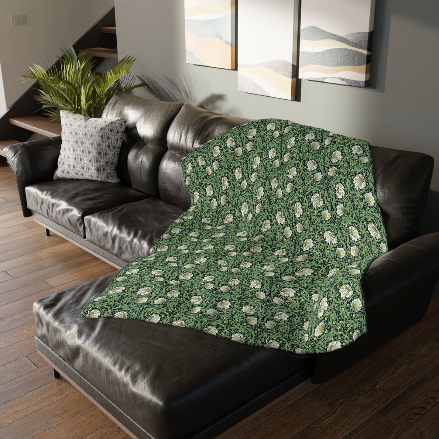 A rectangular blanket with a two-sided print featuring William Morris & Co floral patterns in shades of slate and green in a pattern called Pimpernel with a luxurious velveteen texture.