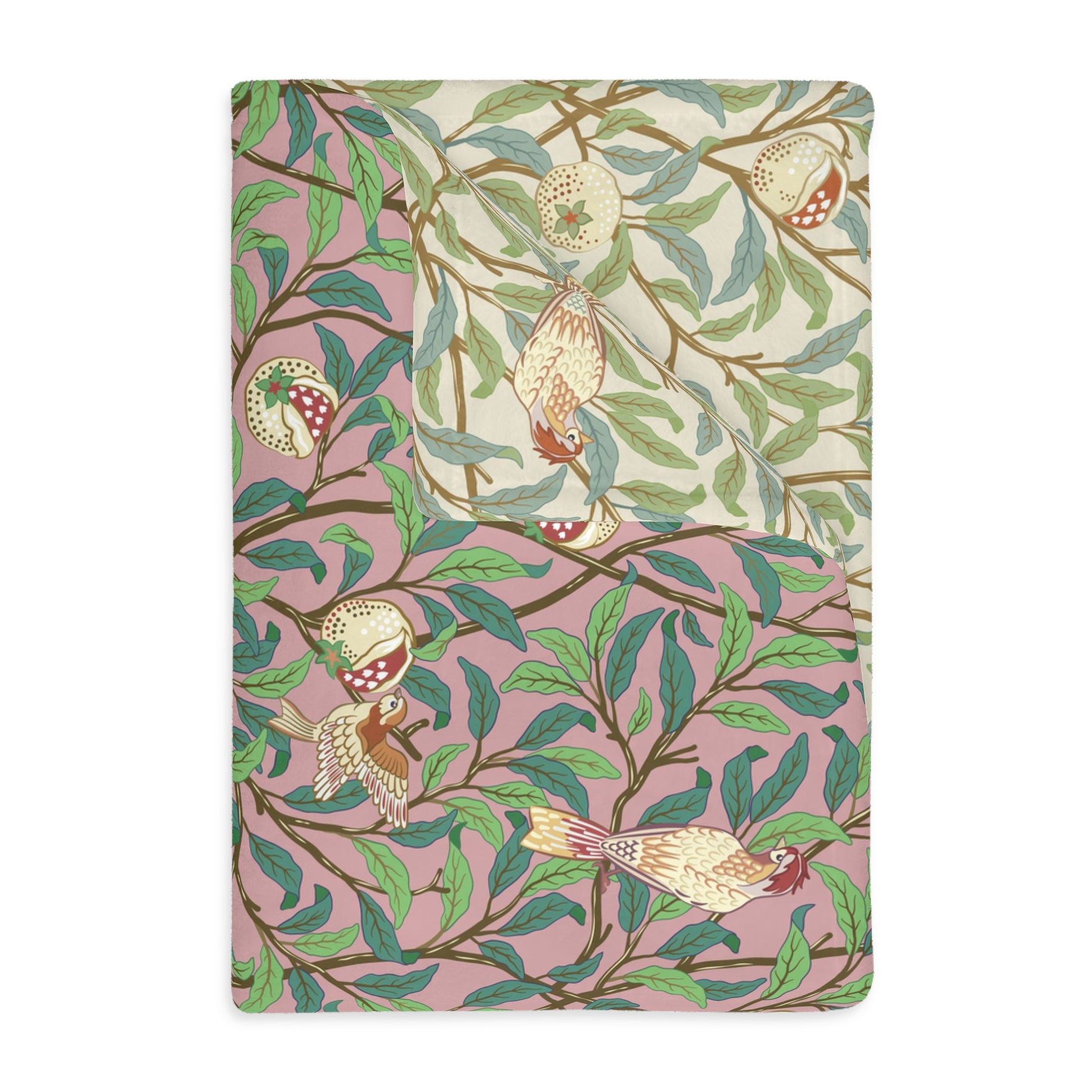 A rectangular blanket with a two-sided print featuring birds and pomegranate leaves on a pink background, inspired by William Morris.