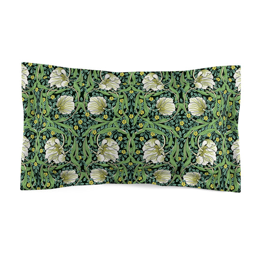 Pillow sham with a floral design inspired by William Morris in green and white colors on a king-sized bed.