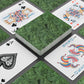 Playing cards with decorative green backs and colorful suits on a gray surface