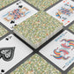 Playing cards with floral design and colorful joker card on a black surface