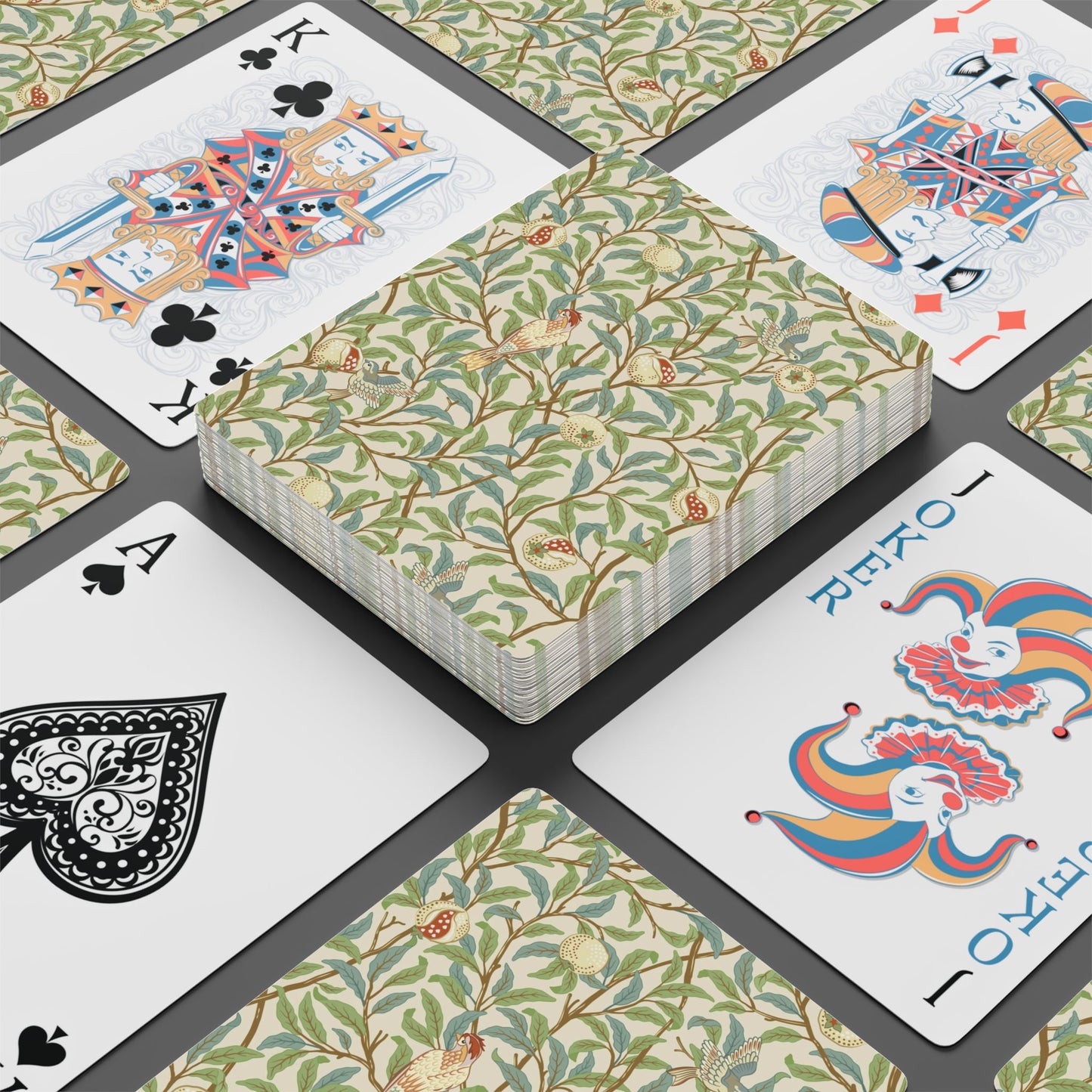 Playing cards with floral design and colorful joker card on a black surface
