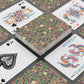 Playing cards with floral design and colorful joker card on a black surface