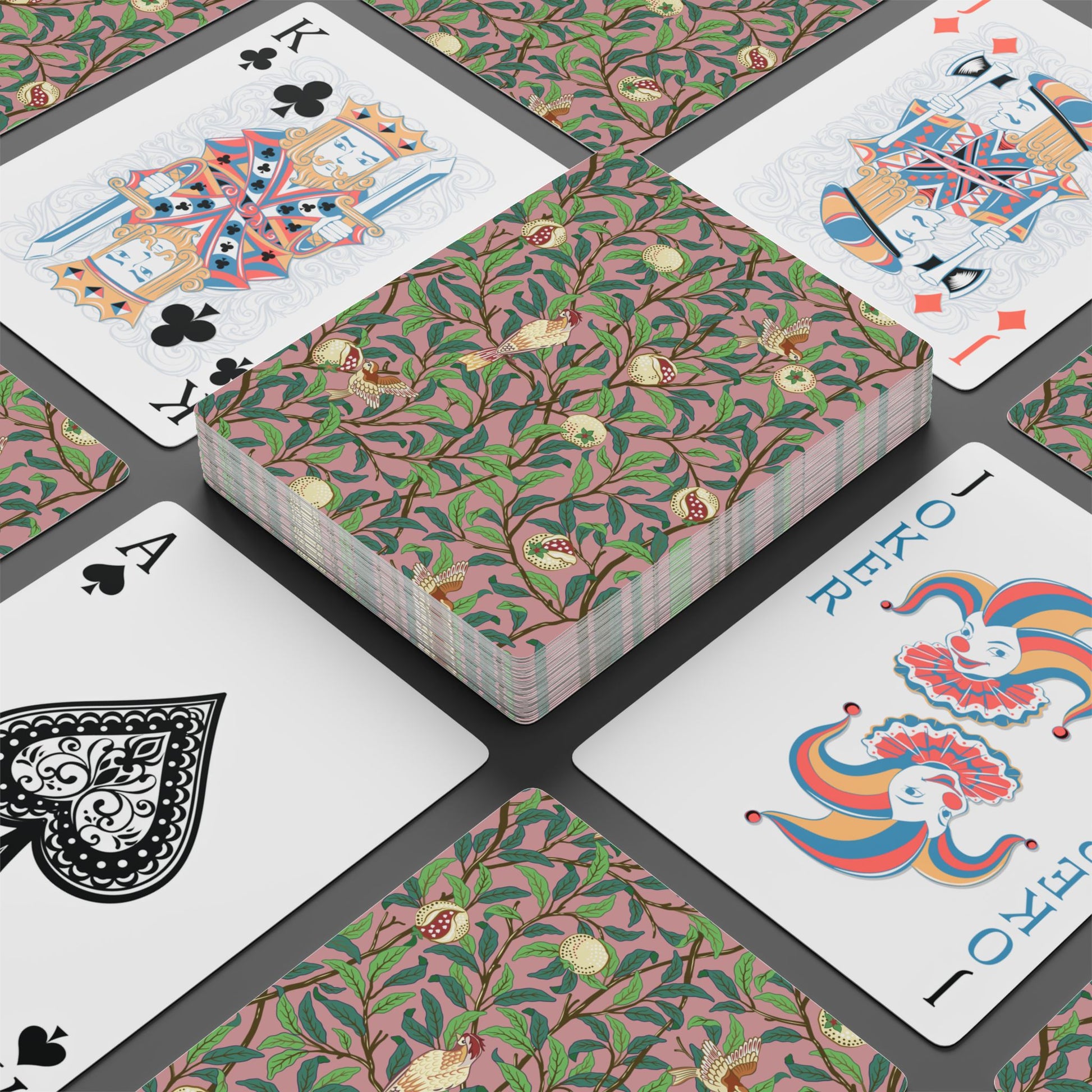Playing cards with floral design and colorful joker card on a black surface