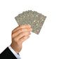 Hand holding a deck of playing cards with a floral pattern on a white background