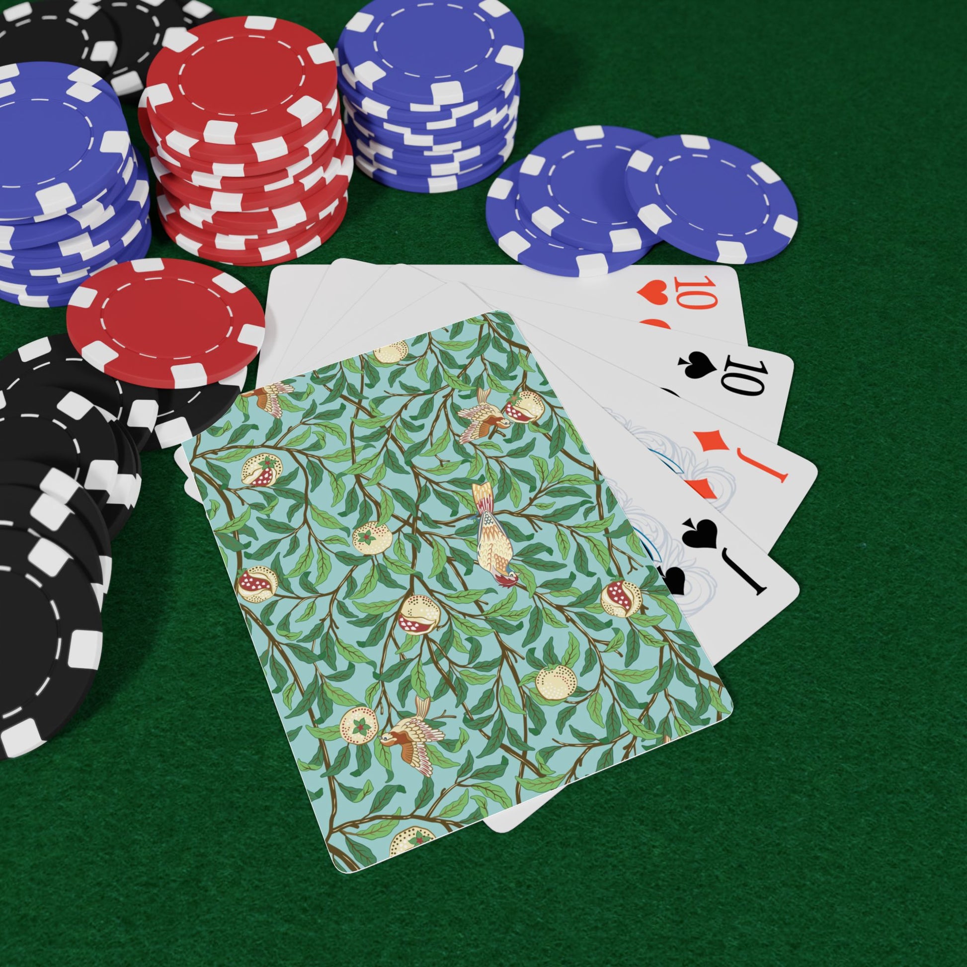 Poker chips and playing cards on a green surface