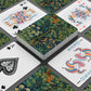 Playing cards with floral design and colorful jester card on a dark surface