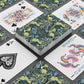 Playing cards with floral design and colorful joker card on a black surface