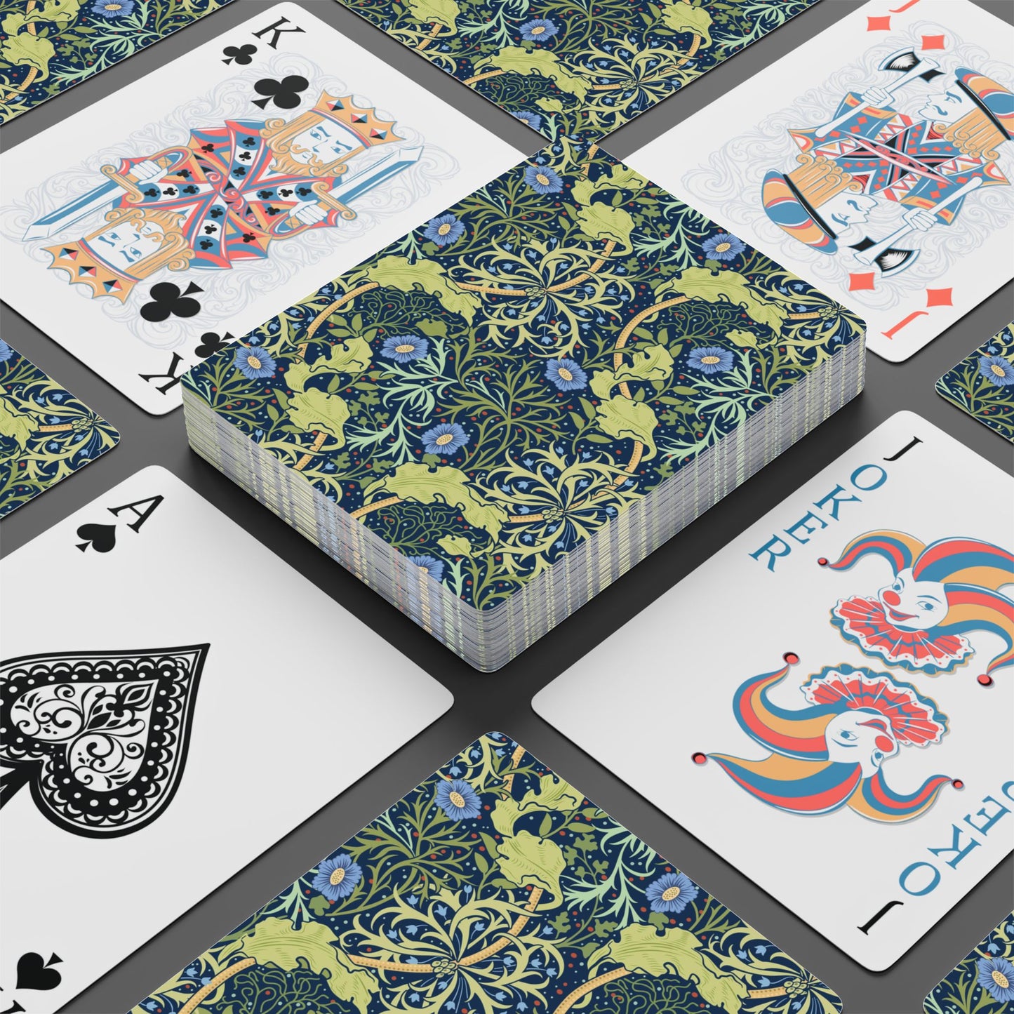 Playing cards with floral design and colorful joker card on a black surface