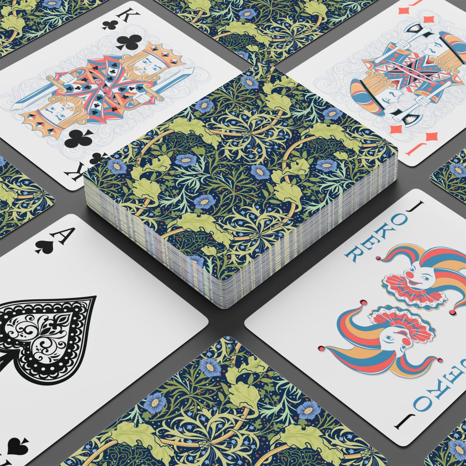 Playing cards with floral design and colorful joker card on a black surface