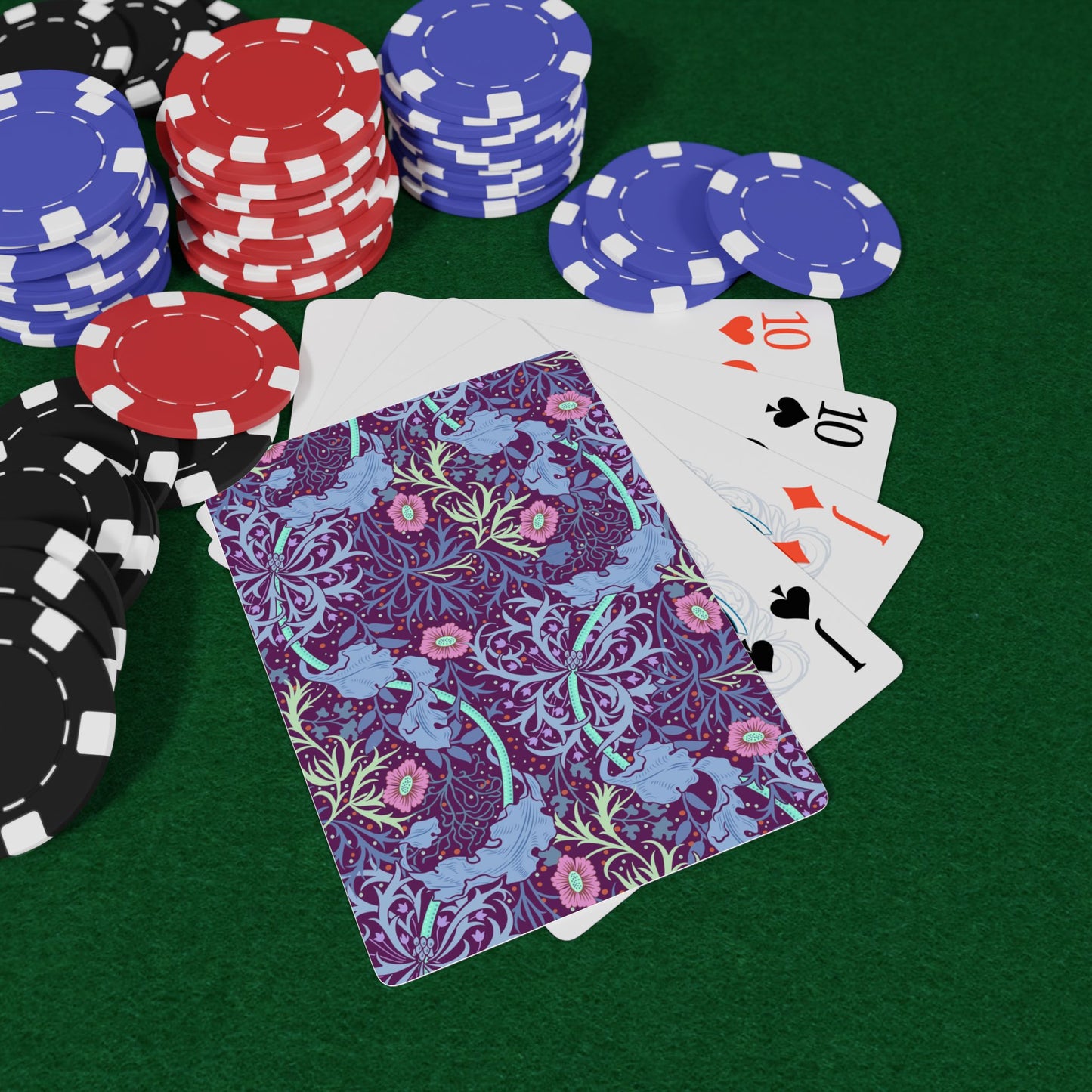 Poker chips and playing cards on a green felt surface