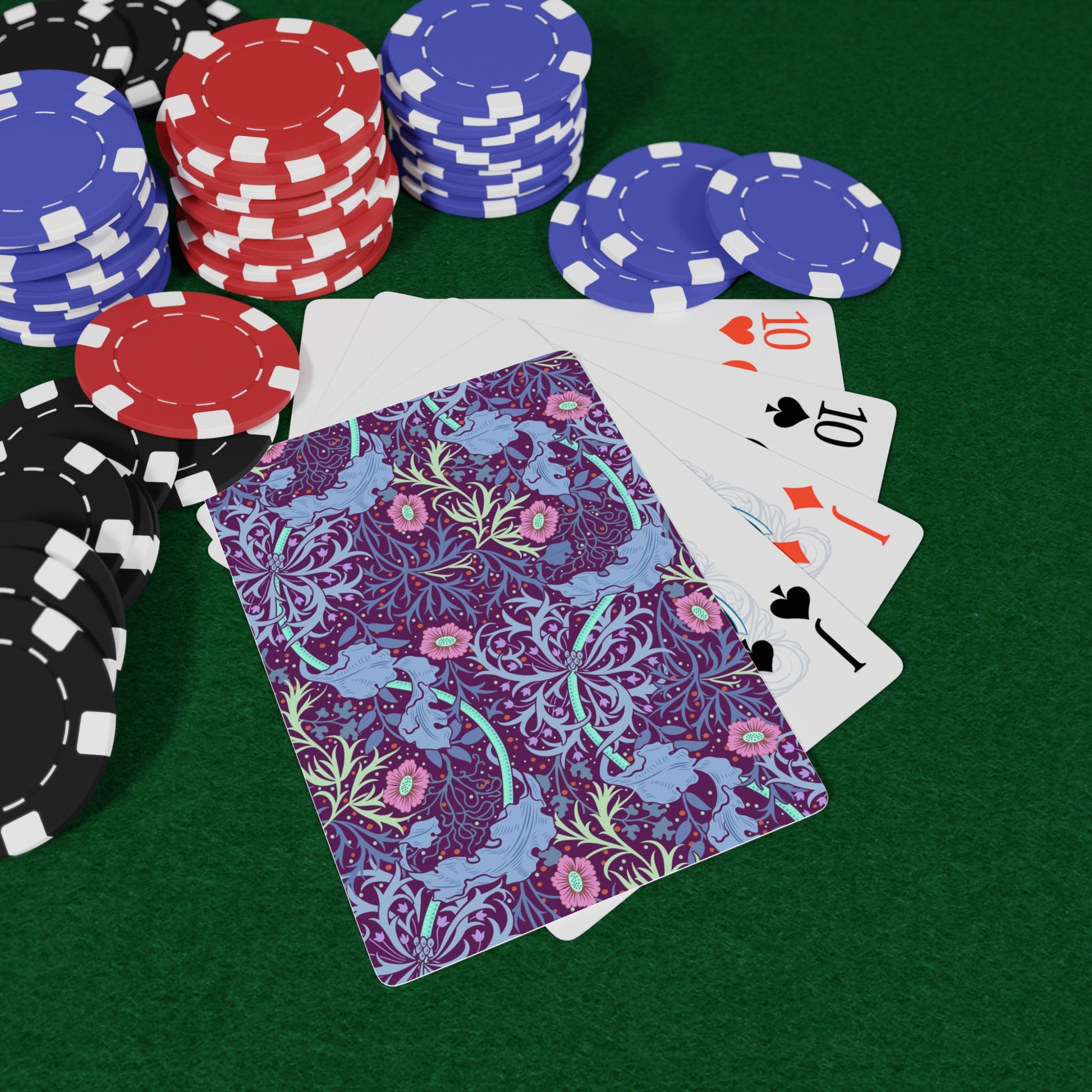 Poker chips and playing cards on a green felt surface