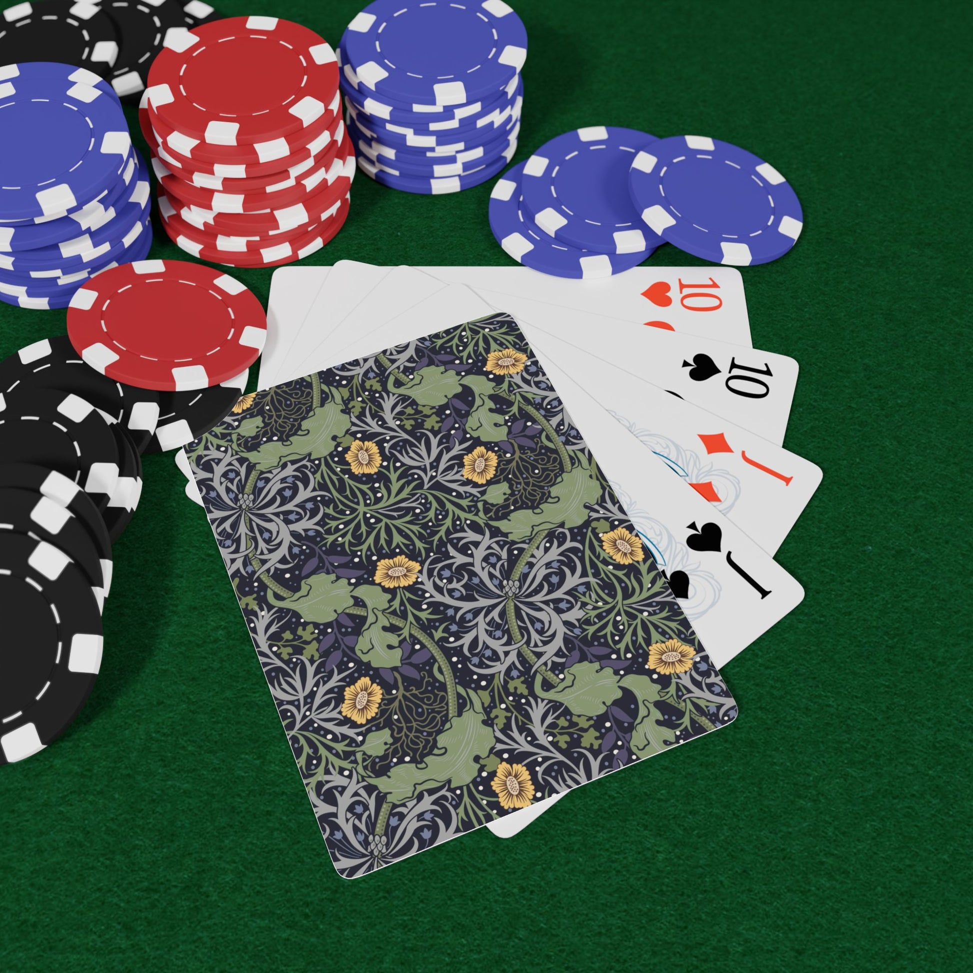 Poker chips and playing cards on a green felt surface