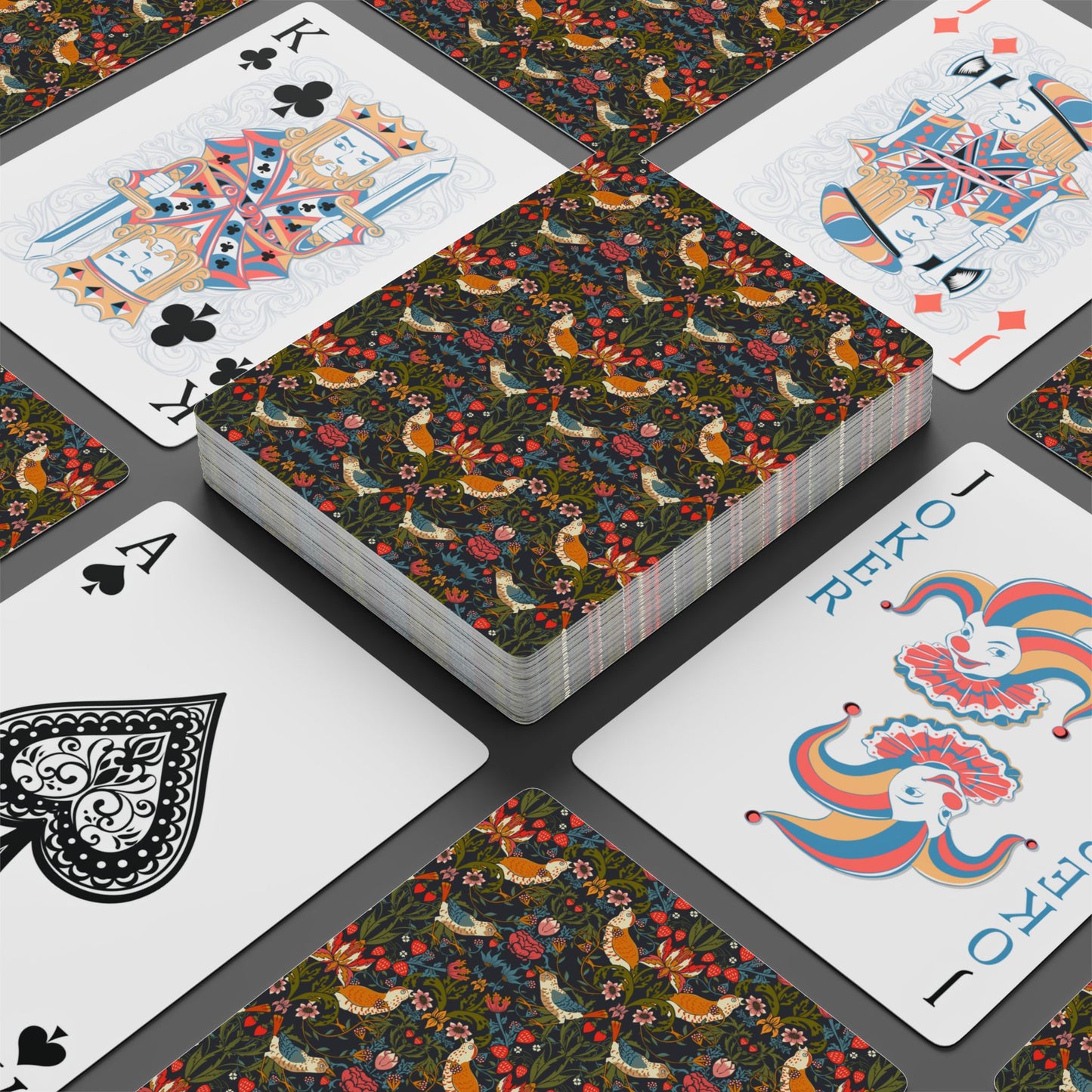 Playing cards with floral and animal pattern on a gray surface
