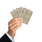Hand holding a deck of playing cards with a geometric pattern on a white background