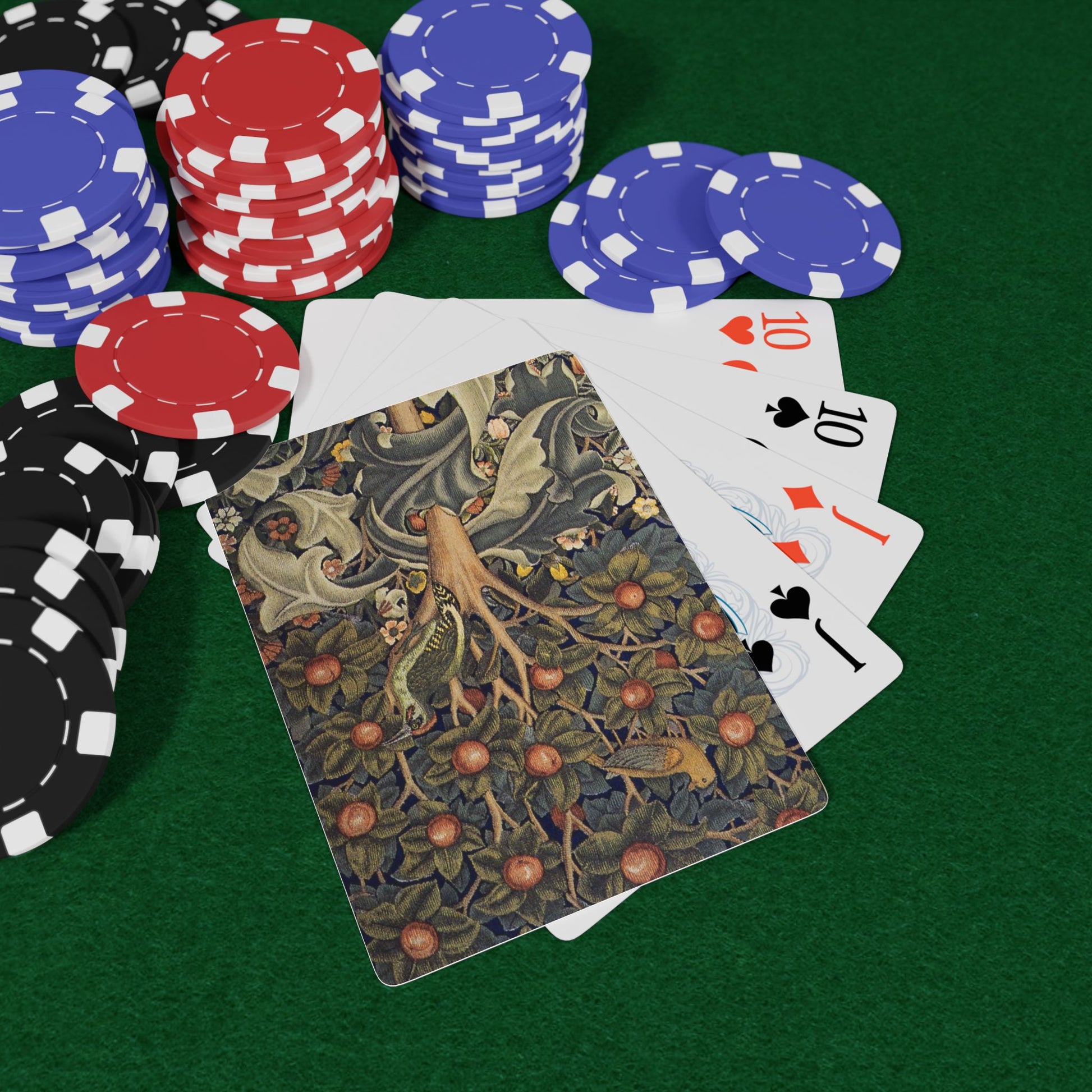 Poker chips and playing cards on a green felt surface