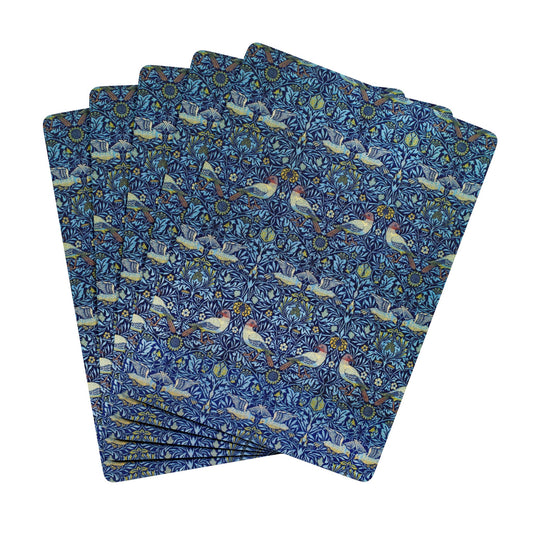 Set of blue patterned placemats with birds and flowers on a white background