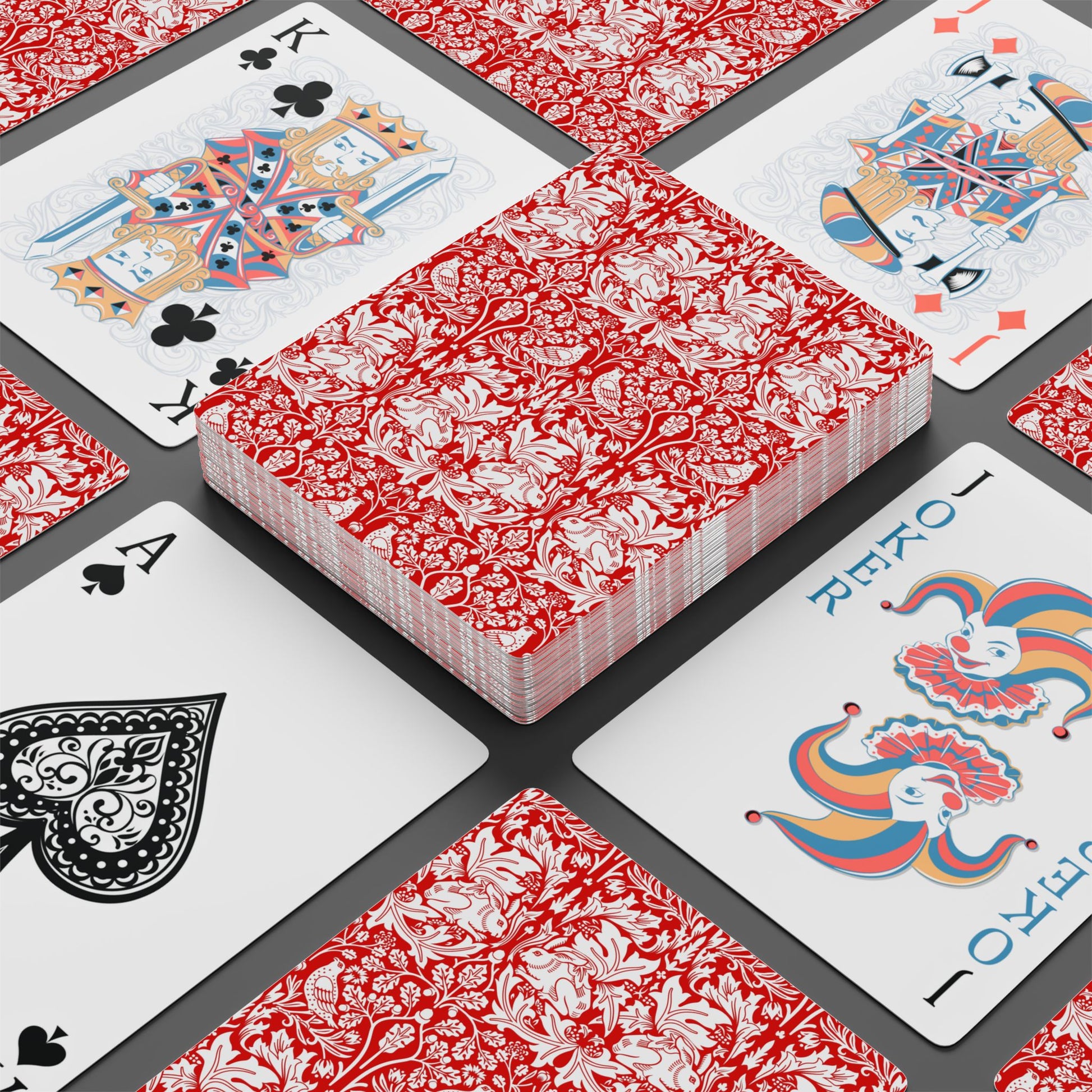 Playing cards with red and white floral design on a black surface