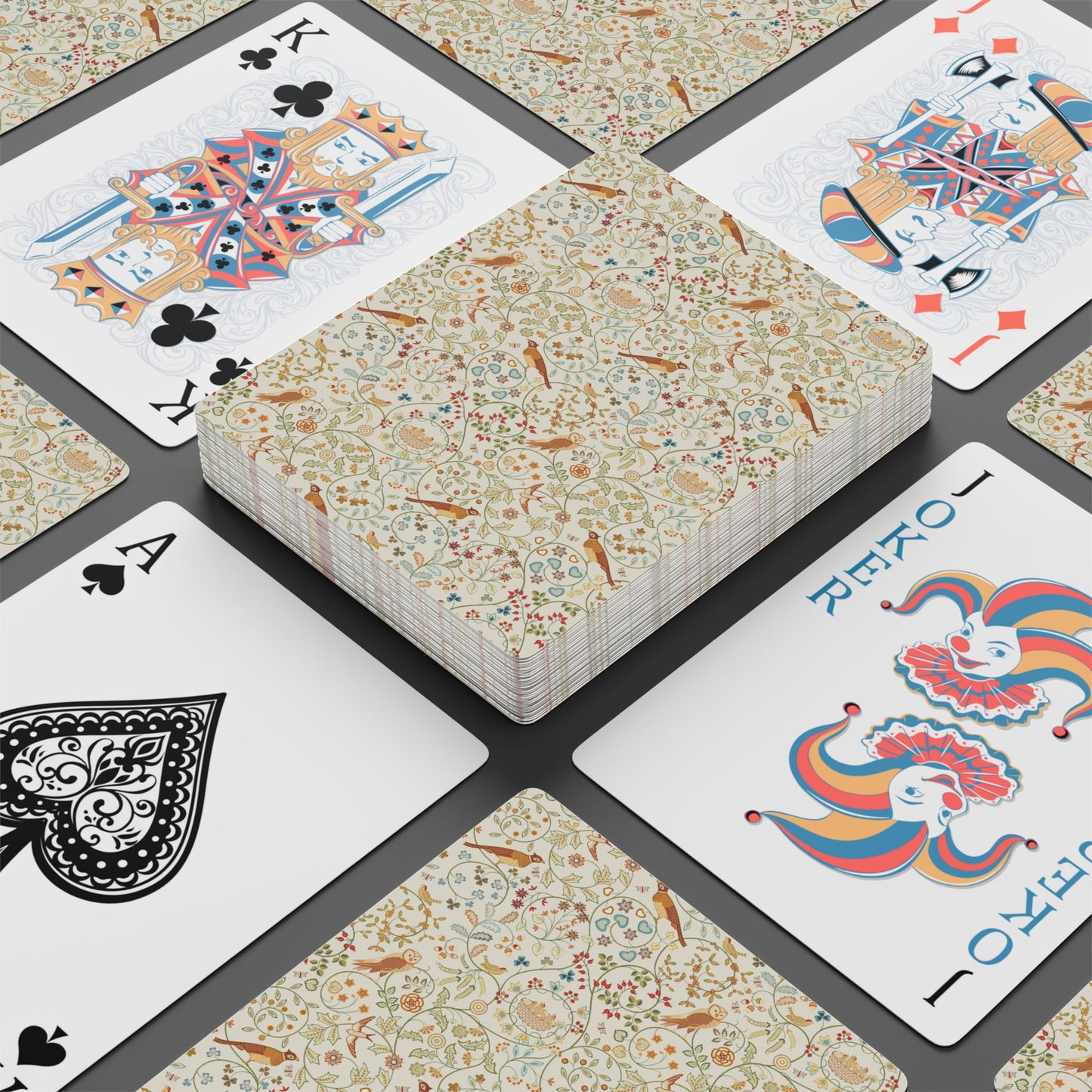 Playing cards with floral design and colorful cardinals on a checkered background