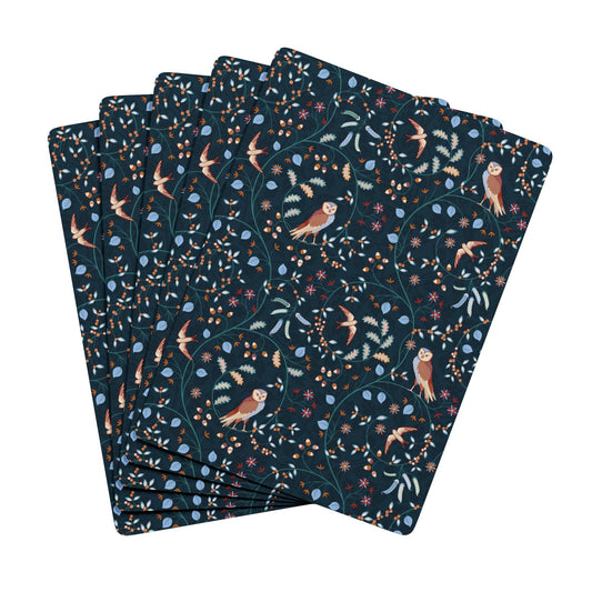 Set of dark blue playing cards with nature-themed pattern on a white background