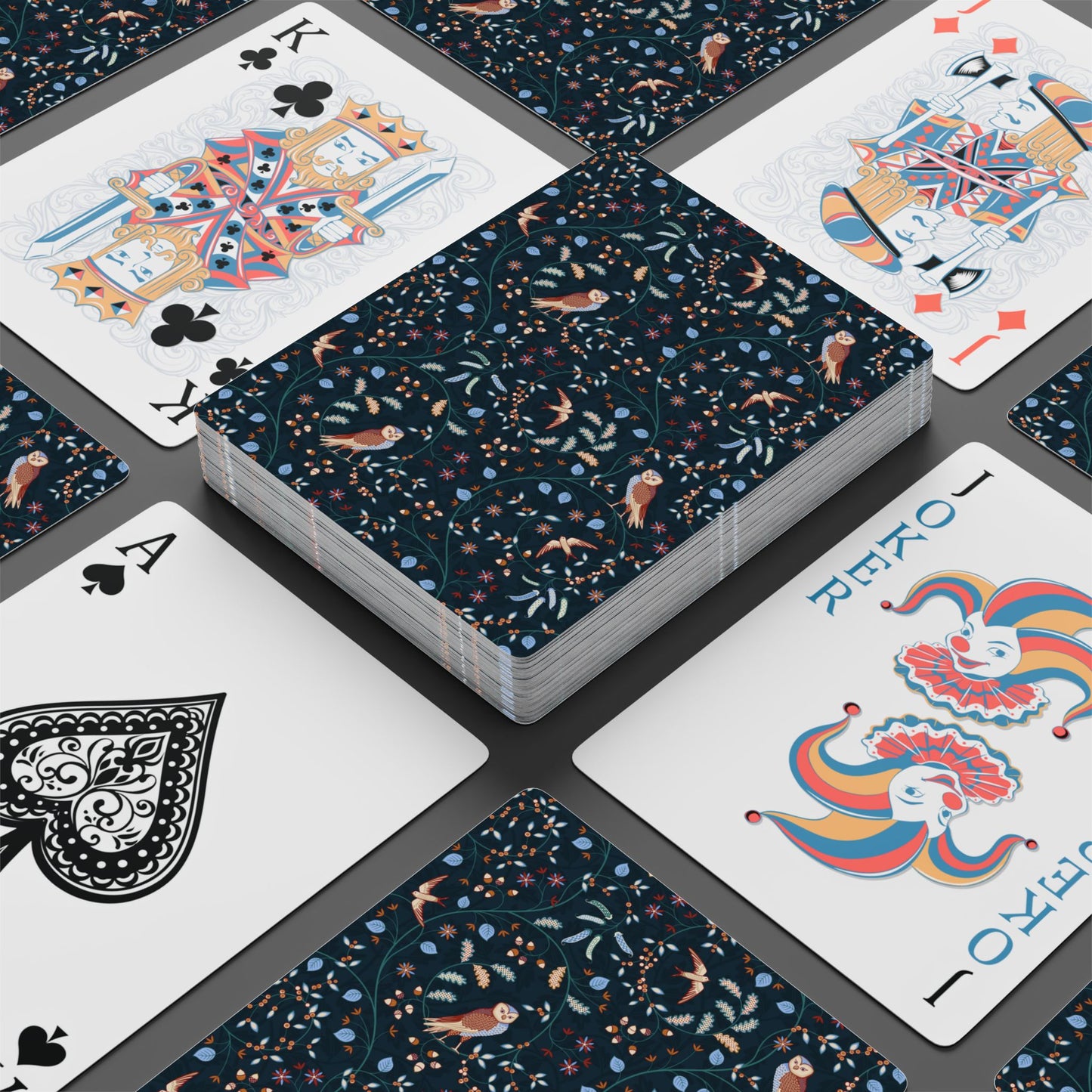 Playing cards with floral and abstract designs on a dark surface